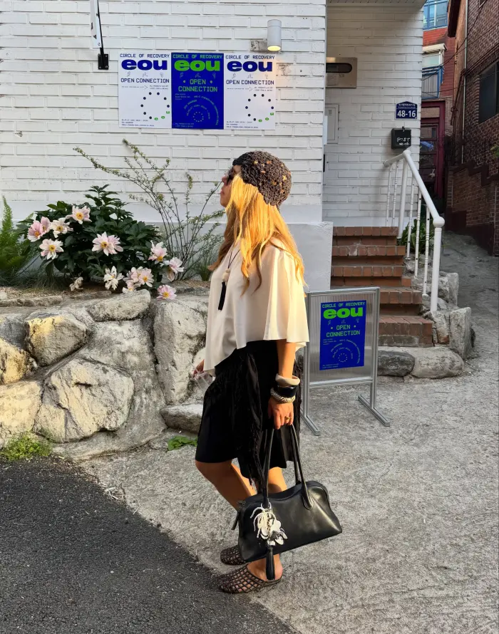 @jessjepson_ wearing black tailored jorts with black jelly shoes, a white top, and black & white accessories.
