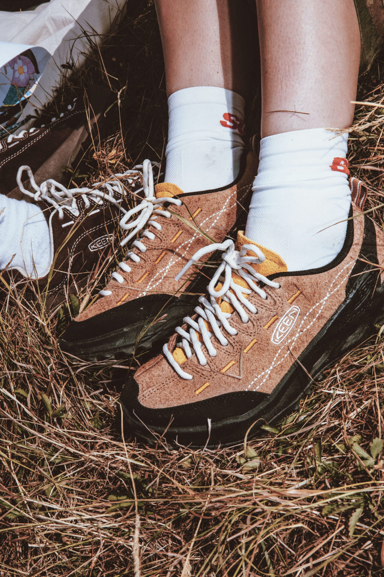 A close up of the beige KEEN Jasper Zionic shoes, worn with white socks.