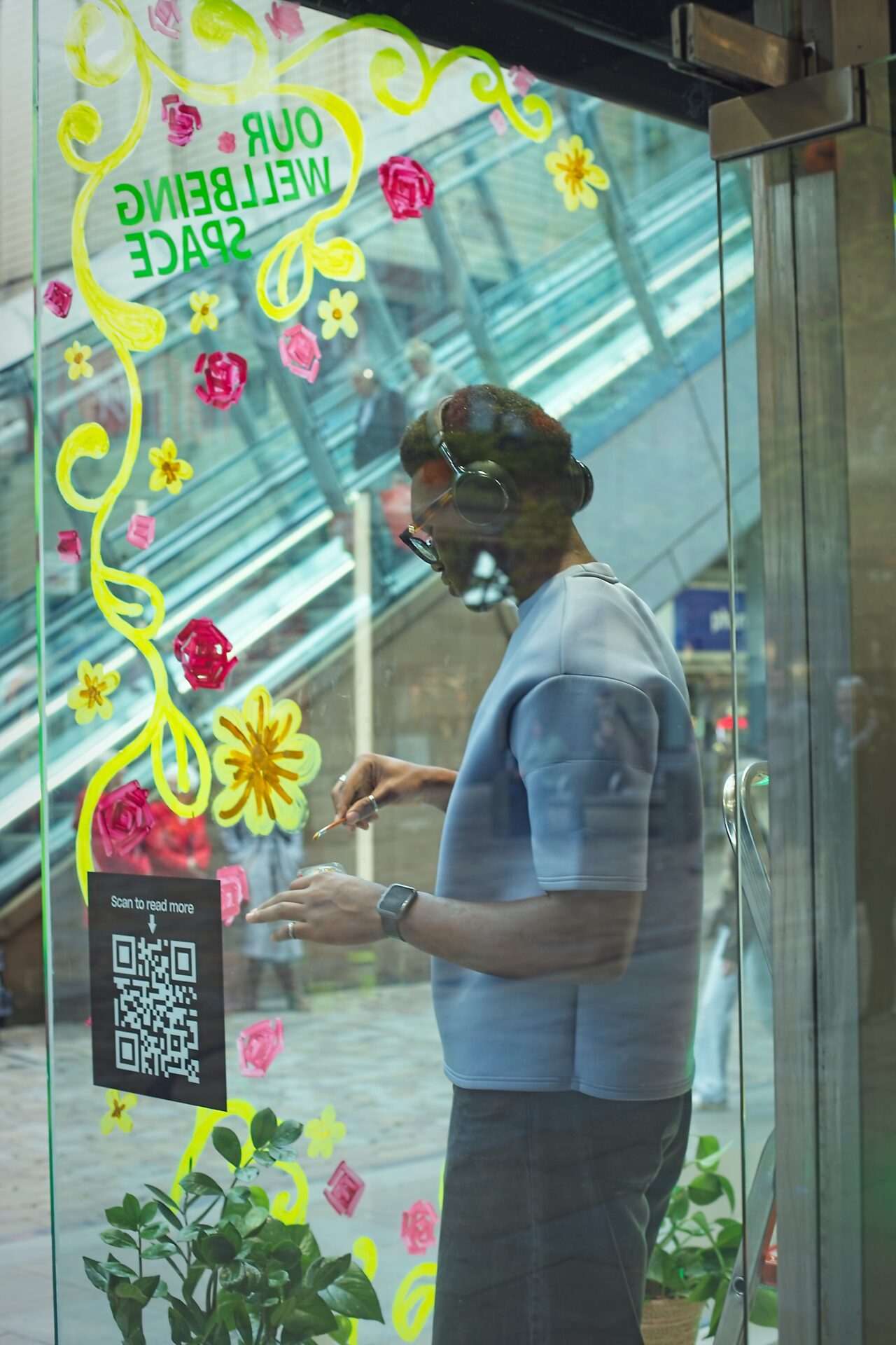 Artist Obiaje Andrew Ejiga working on the store window.