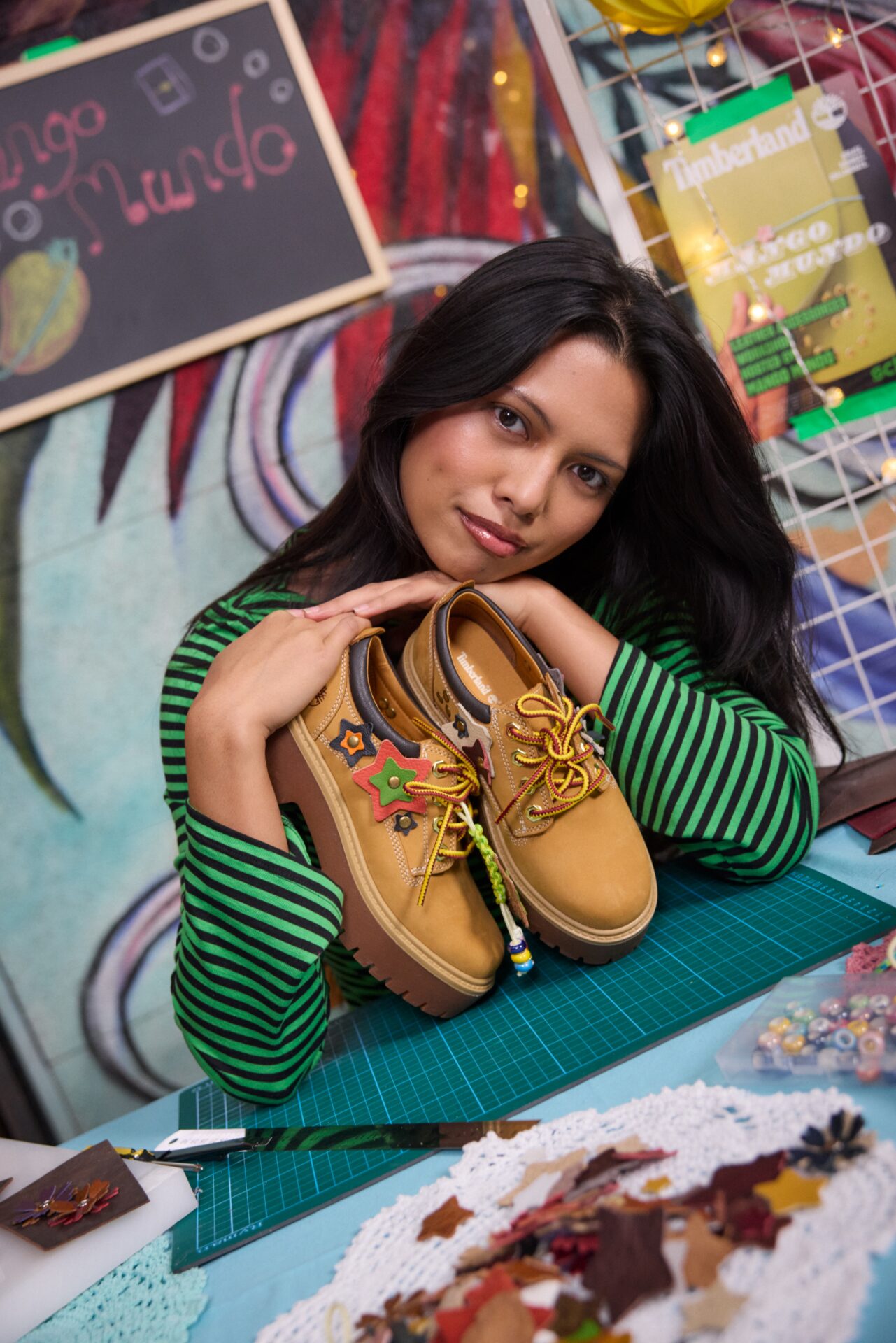 Campaign star Mango Mundo holding a pair of Timberland Stone Street shoes she customised.